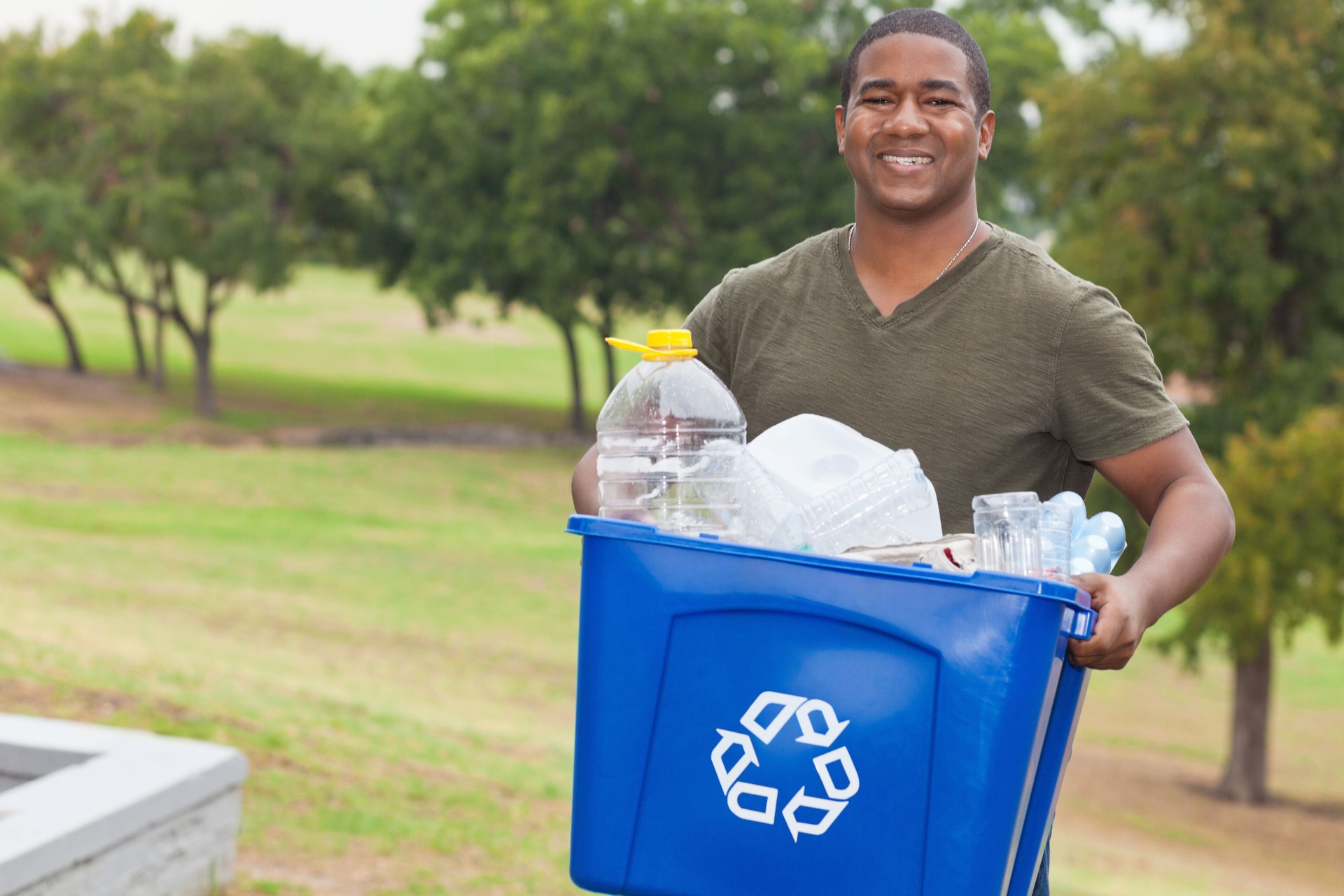 Man holding a recycle bin full of garbage